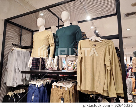 SELANGOR, MALAYSIA -APRIL 4, 2022: Various types of clothes are being sold in the store. Displayed by hanging and folding. Have a price tag for buyer review. Separated by type and brand SELANGOR, MALAYSIA -APRIL 4, 2022: Various types of clothes are being sold in the store. Displayed by hanging and folding. Have a price tag for buyer review. Separated by type and brand 92645326