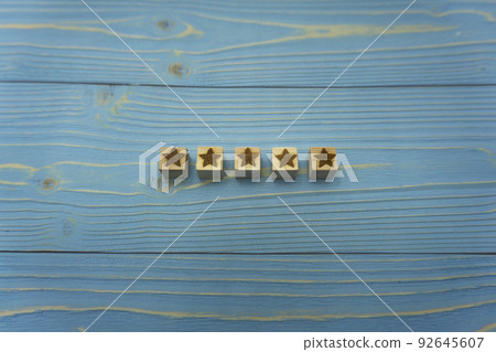 藍色木甲板中心排列的五星級木立方體的審查和評價背景 92645607