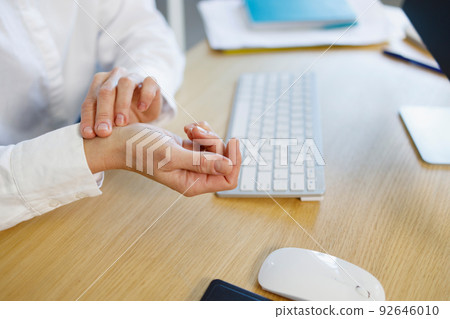 Closeup view of business woman's hands measuring her hearth rate Closeup view of business woman's hands measuring her hearth rate 92646010