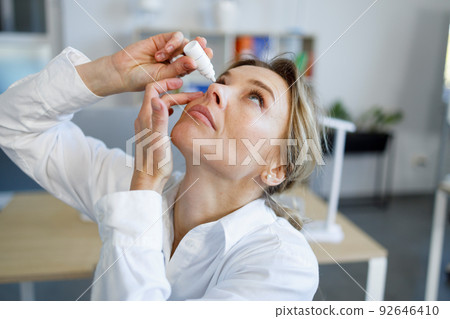 Business woman office worker dripping eye drops Business woman office worker dripping eye drops 92646410