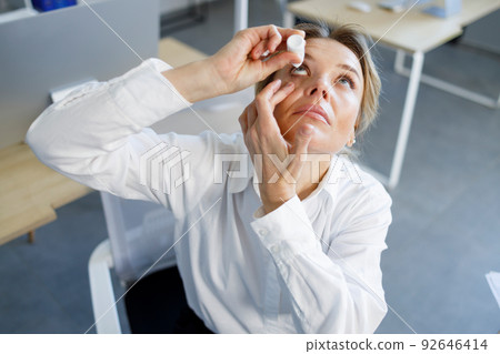 Business woman applying eye drops. Occupational disease concept Business woman applying eye drops. Occupational disease concept 92646414