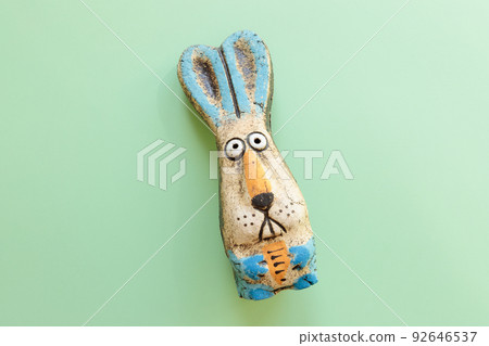Shocked eyes of toy hare on green background with copy space. Rabbit toy, symbol of the new year 2023. 92646537