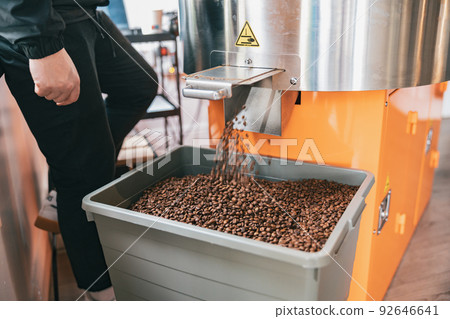 Roasted coffee beans from roaster machine pouring into the special box for selling Roasted coffee beans from roaster machine pouring into the special box for selling 92646641