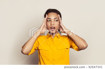 Surprised woman touching herself head on white background 92647341