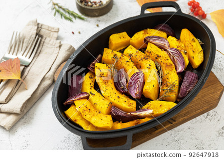 Healthy baked food. Keto, paleo diet, veggie or vegetarian meal. Roasted pumpkins slice with rosemary and purple onion on a stone tabletop. Healthy baked food. Keto, paleo diet, veggie or vegetarian meal. Roasted pumpkins slice with rosemary and purple onion on a stone tabletop. 92647918
