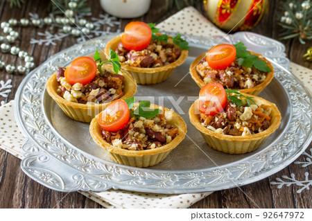 Tartlets with beans, meat and walnuts. Beautiful Christmas and New Year's food background. Selective focus. Tartlets with beans, meat and walnuts. Beautiful Christmas and New Year's food background. Selective focus. 92647972