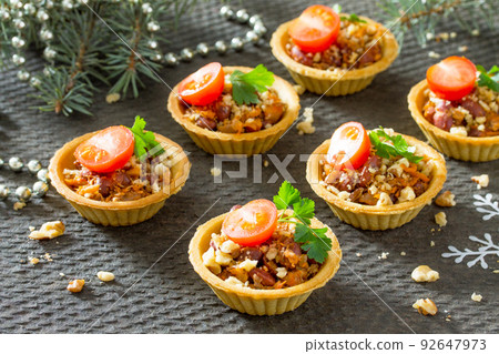 Tartlets with beans, meat and walnuts. Beautiful Christmas and New Year's food background. Selective focus. Tartlets with beans, meat and walnuts. Beautiful Christmas and New Year's food background. Selective focus. 92647973