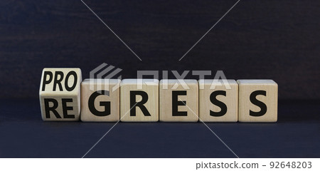 Regress or progress symbol. Turned wooden cubes and changed the word Regress to Progress. Beautiful black table black background. Business regress or progress concept. Copy space. Regress or progress symbol. Turned wooden cubes and changed the word Regress to Progress. Beautiful black table black background. Business regress or progress concept. Copy space. 92648203