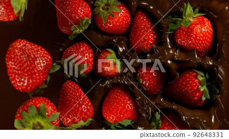 Falling Strawberries into Dark Hot Melted Chocolate, Close-up. Falling Strawberries into Dark Hot Melted Chocolate, Close-up. 92648331