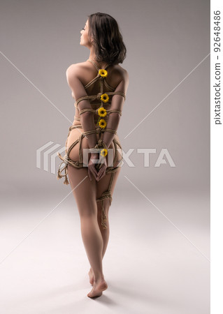 Anonymous naked woman tied with ropes with flowers Anonymous naked woman tied with ropes with flowers 92648486