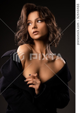 Attractive woman in dress standing in studio Attractive woman in dress standing in studio 92648488