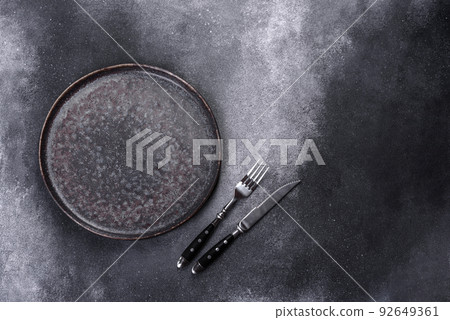 Black plate on a black background. Flat lay, top view, copy space Black plate on a black background. Flat lay, top view, copy space 92649361