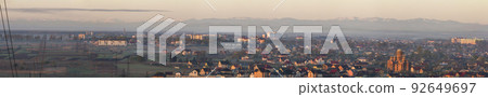 Wide panorama, aerial view of Ivano-Frankivsk city, Ukraine. Scene of modern tourist city with tall buildings, residential quarters and green streets on background of distant Carpathian mountains. 92649697