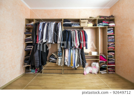 Wardrobe full of different men and woman clothes 92649712