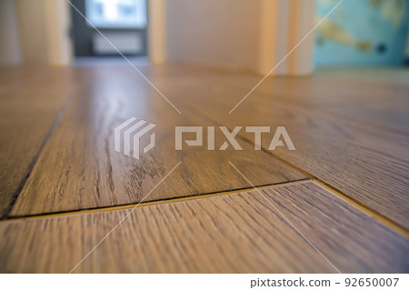 Spacious empty room, wooden floor light brown polished surface background in new apartment interior, beige walls, blurred glass window or door opening. 92650007