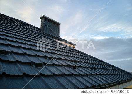 Snow guard for safety in winter on house roof top covered with steel shingles. Tiled covering of building 92650008