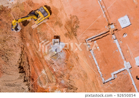 To lay down the underground storm sewer pipes, the excavator digs a pit in order to connect to the sewer system 92650854