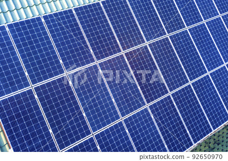 Close-up surface of blue shiny solar photo voltaic panels system on building roof. Renewable ecological green energy production concept. 92650970