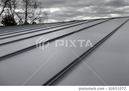 Close-up detail of house roof made from gray metal sheets. Close-up detail of house roof made from gray metal sheets. 92651072