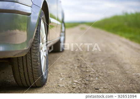 Close-up detail of car part, wheels with aluminum disc and black rubber tire protector on light outdoors background. Traveling and vehicles concept. 92651094