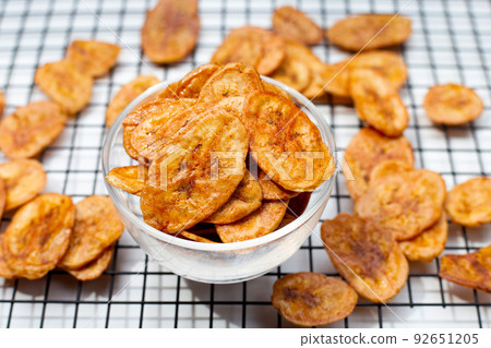 Banana chips on white background Banana chips on white background 92651205