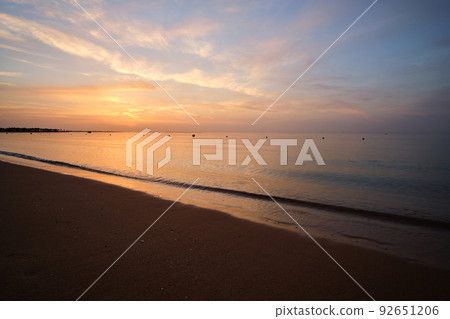 Calm sea shore with crushing waves on sandy beach at sunrise. Calm sea shore with crushing waves on sandy beach at sunrise. 92651206
