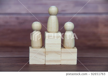 Leadership and winning concept - 3 wooden dolls on top of wooden cube. Copy space Leadership and winning concept - 3 wooden dolls on top of wooden cube. Copy space 92651763