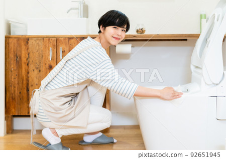 young woman cleaning the toilet 92651945