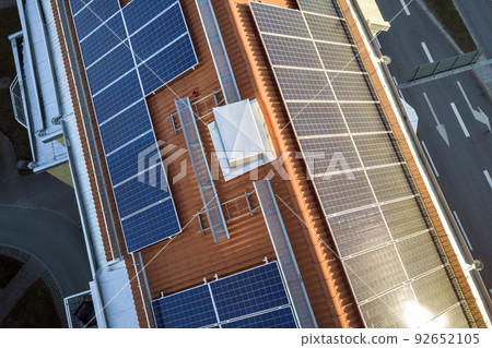 Aerial view of solar photo voltaic panels system on apartment building roof. Renewable ecological green energy production concept. 92652105
