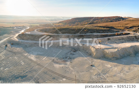 Aerial view of open pit mining site of limestone materials for construction industry with excavators and dump trucks Aerial view of open pit mining site of limestone materials for construction industry with excavators and dump trucks 92652130