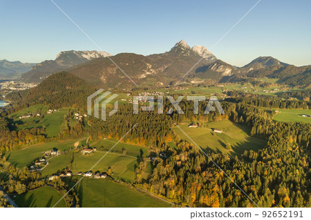 Aerial view of green meadows with villages and forest in austrian Alps mountains. 92652191