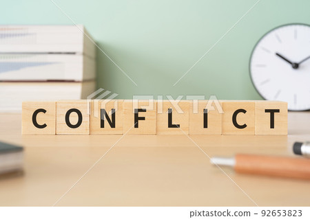 Image of conflict, confrontation, and conflict | A desk with a block written as "CONFLICT" 92653823