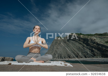 Yoga practice and meditation in nature. Woman practicing near Black sea. Yoga practice and meditation in nature. Woman practicing near Black sea. 92654638