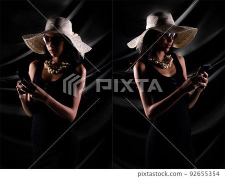 Silhouette of young woman hold internet phone trader online over drape curtain black background 92655354