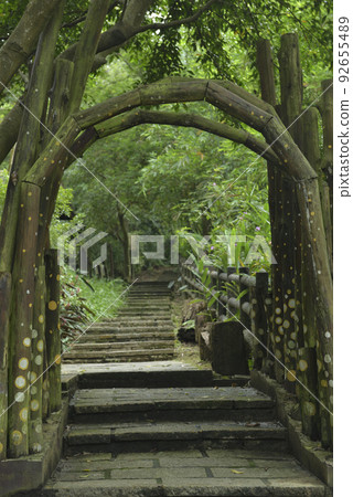 Landscape of trail path and wooden arches in forest park 92655489
