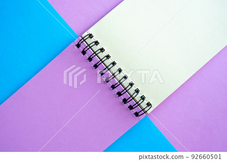 notebook with multi-colored pages lies on pink and blue background. top view, flatlay, copy space . notebook with multi-colored pages lies on pink and blue background. top view, flatlay, copy space . 92660501