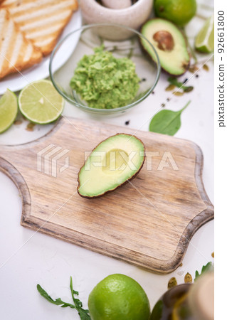 Toasts preparation - Mashed avocados in a glass bowl Toasts preparation - Mashed avocados in a glass bowl 92661800