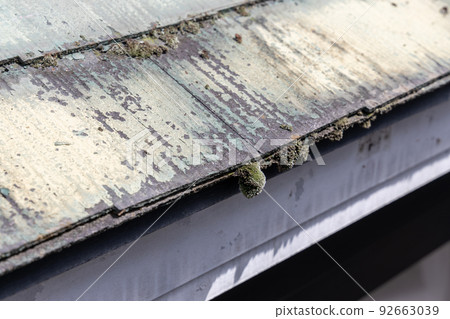 The faded and dirty roof of a 25-year-old detached house 92663039