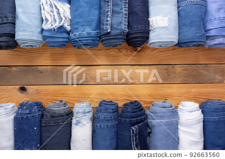 Jeans denim at wooden background texture. Blue Jeans fabric on tabletop 92663560