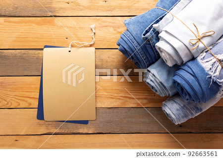 Jeans denim and price tag label on wooden background texture. Blue jeans denim fabric 92663561