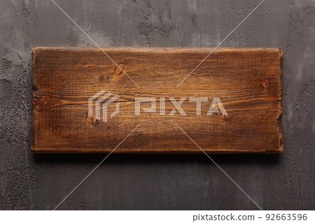 Wooden nameplate or sign board screwed at wall background. Front view of name plate 92663596