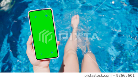 girl use phone on pool 92663601