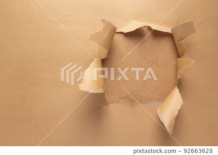 Cardboard torn paper as background texture. Brown paper hole Cardboard torn paper as background texture. Brown paper hole 92663628
