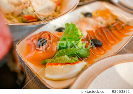 Dish. Sliced red fish, lettuce, lemon, olives, microgreens 92663851