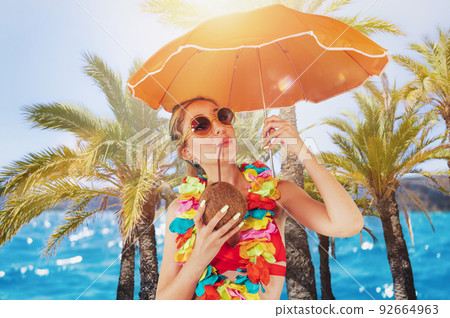 Woman cover herself from the sun radiation with an umbrella Woman cover herself from the sun radiation with an umbrella 92664963