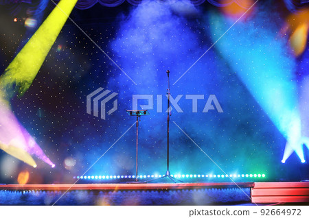 Elegant theatre show with colored spotlights and microphone Elegant theatre show with colored spotlights and microphone 92664972