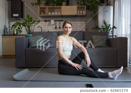 Woman at home doing morning exercises, doing fitness Woman at home doing morning exercises, doing fitness 92665374
