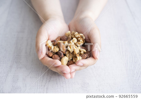 Woman's hand holding mixed nuts 92665559