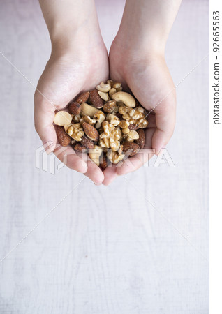Woman's hand holding mixed nuts 92665563