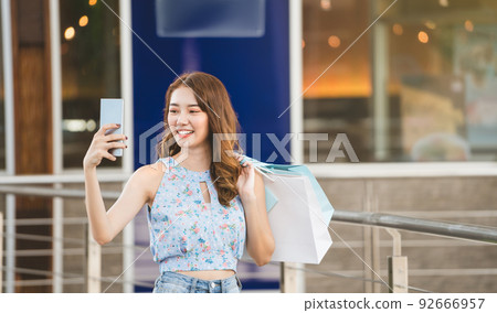 Asia young woman use mobilephone when shopping Asia young woman use mobilephone when shopping 92666957